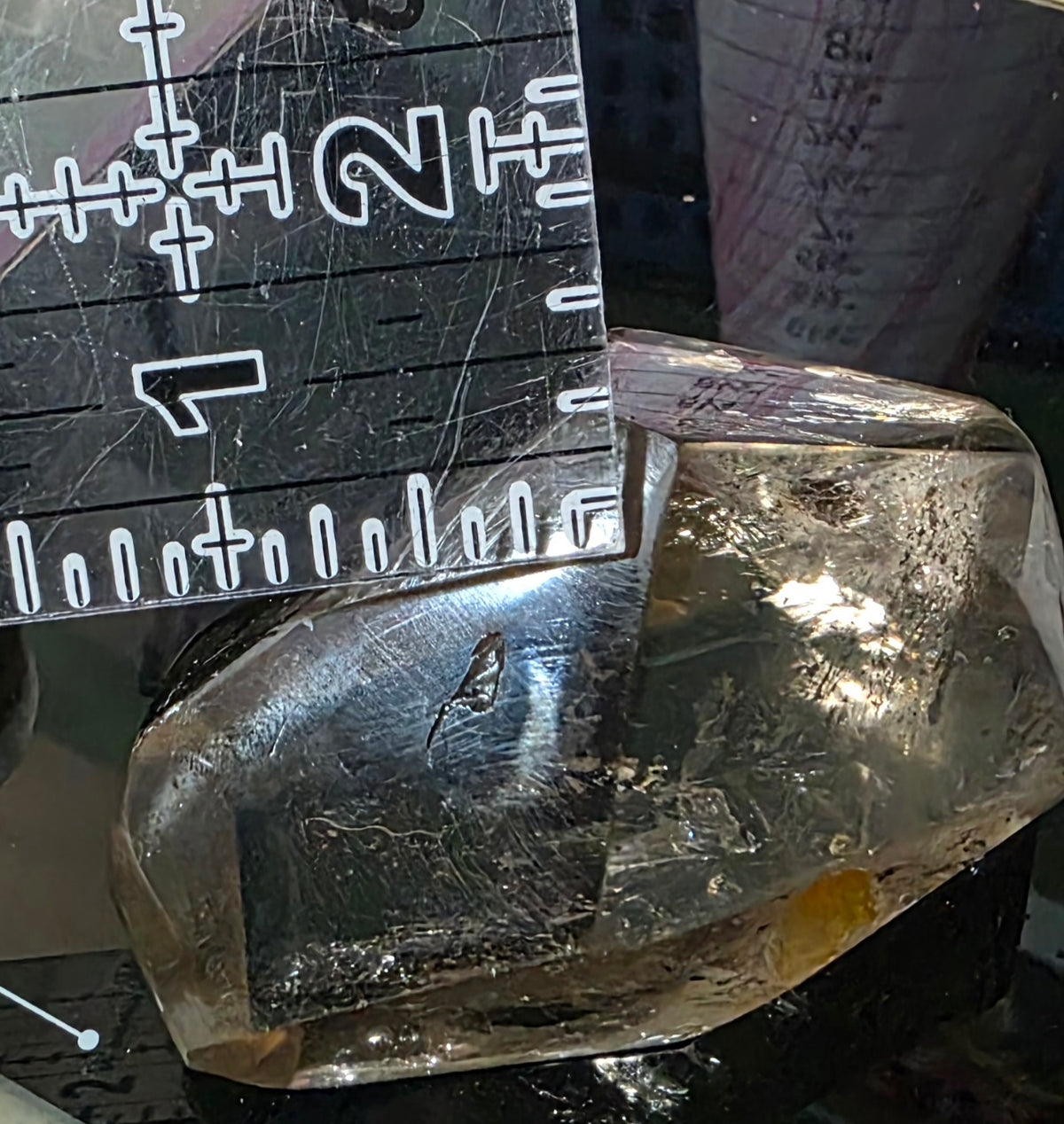 Smoky Quartz freeform under magnification showing the small chip along one polished facet.