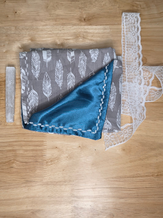 Gray feather-print tarot wrap with teal satin lining, white lace, and selenite stick included.