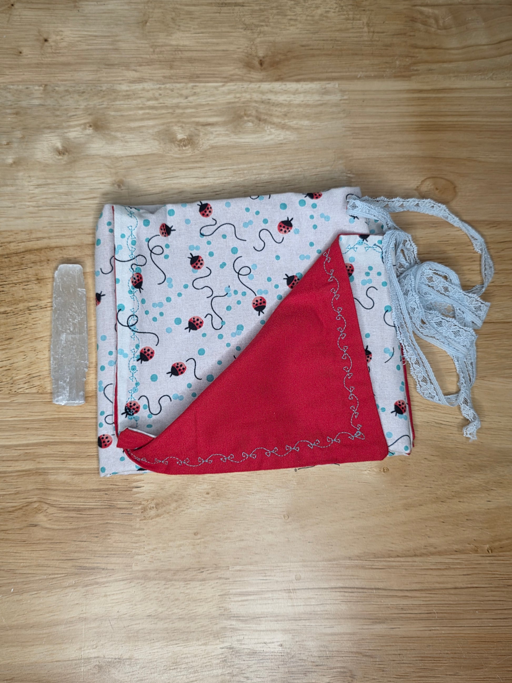 Ladybug-print tarot wrap with red lining, blue lace tie, and included selenite stick.