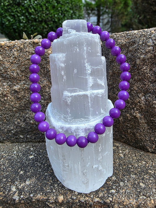 Phosphosiderite bracelet featuring round 8mm deep violet beads on a selenite tower; offers stress relief and spiritual connection.