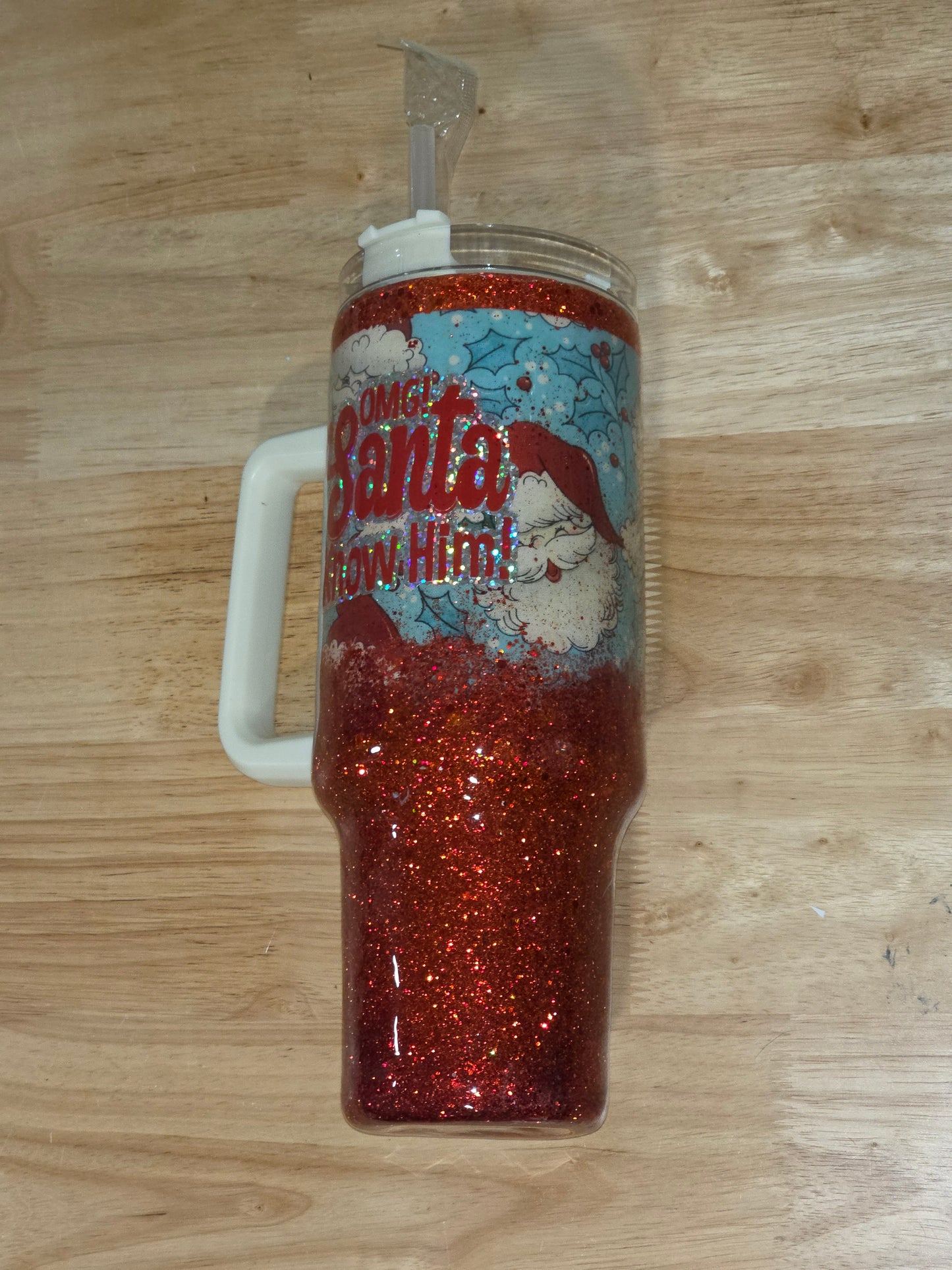 Angled view of the tumbler showing the handle and layered vinyl design with red glitter base.