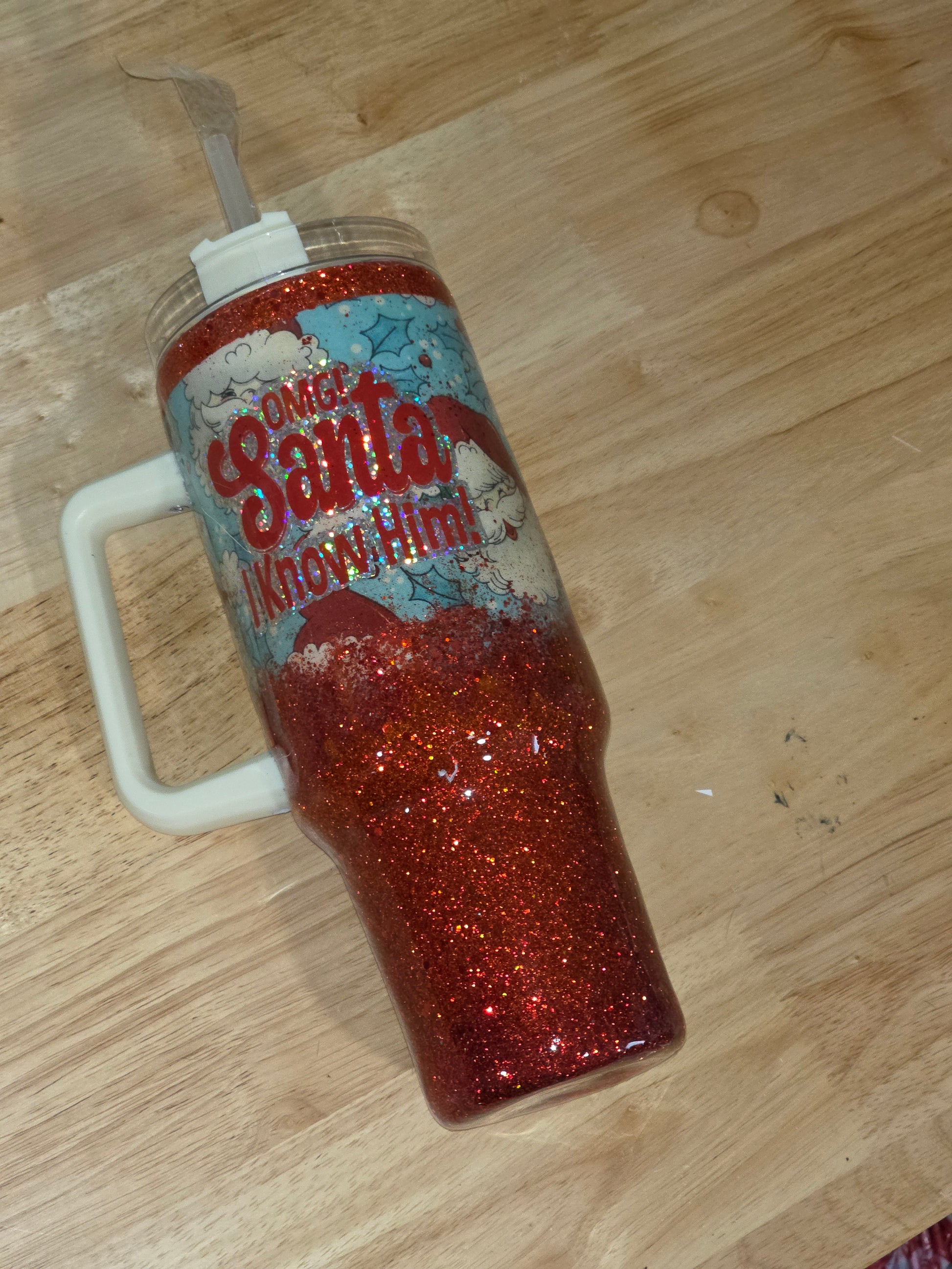 Angled view of the tumbler showing the handle and layered vinyl design with red glitter base.