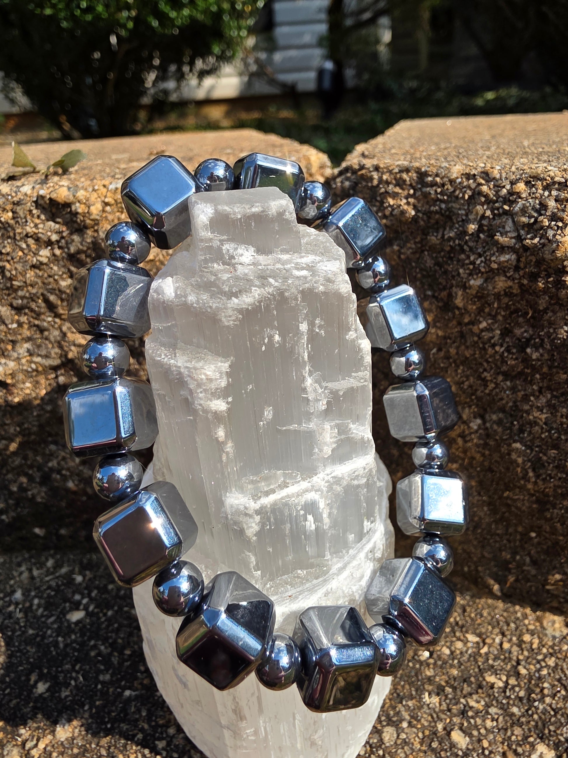 Terahertz cube bracelet featuring reflective metallic silver cube beads alternated with small round spacers, wrapped around a selenite tower on natural stone. This high-frequency stone is said to enhance energy flow, relieve fatigue and provide EMF protection.