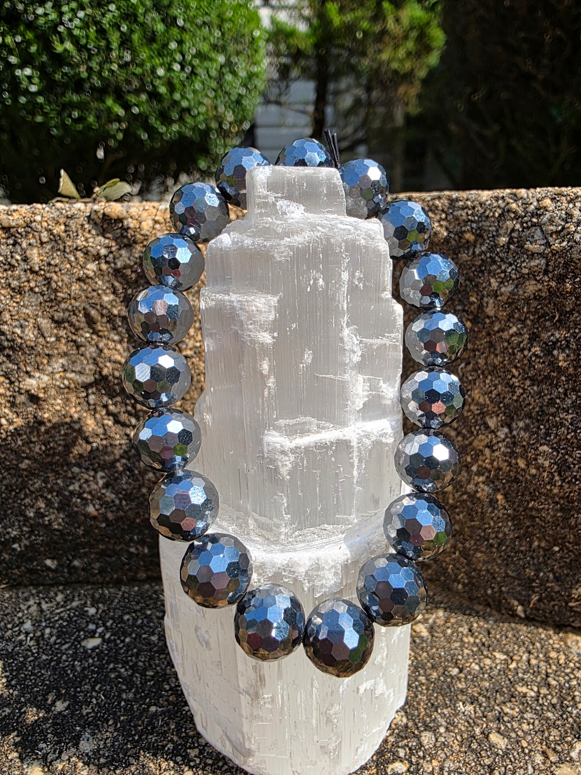 Terahertz faceted bracelet featuring reflective metallic grey faceted beads around a selenite tower; promotes vitality, stress relief, and electromagnetic healing.