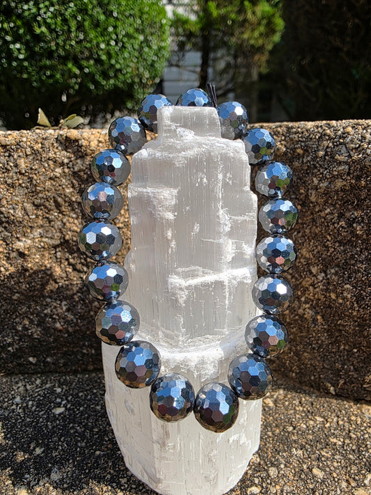 Terahertz faceted bracelet featuring reflective metallic grey faceted beads around a selenite tower; promotes vitality, stress relief, and electromagnetic healing.