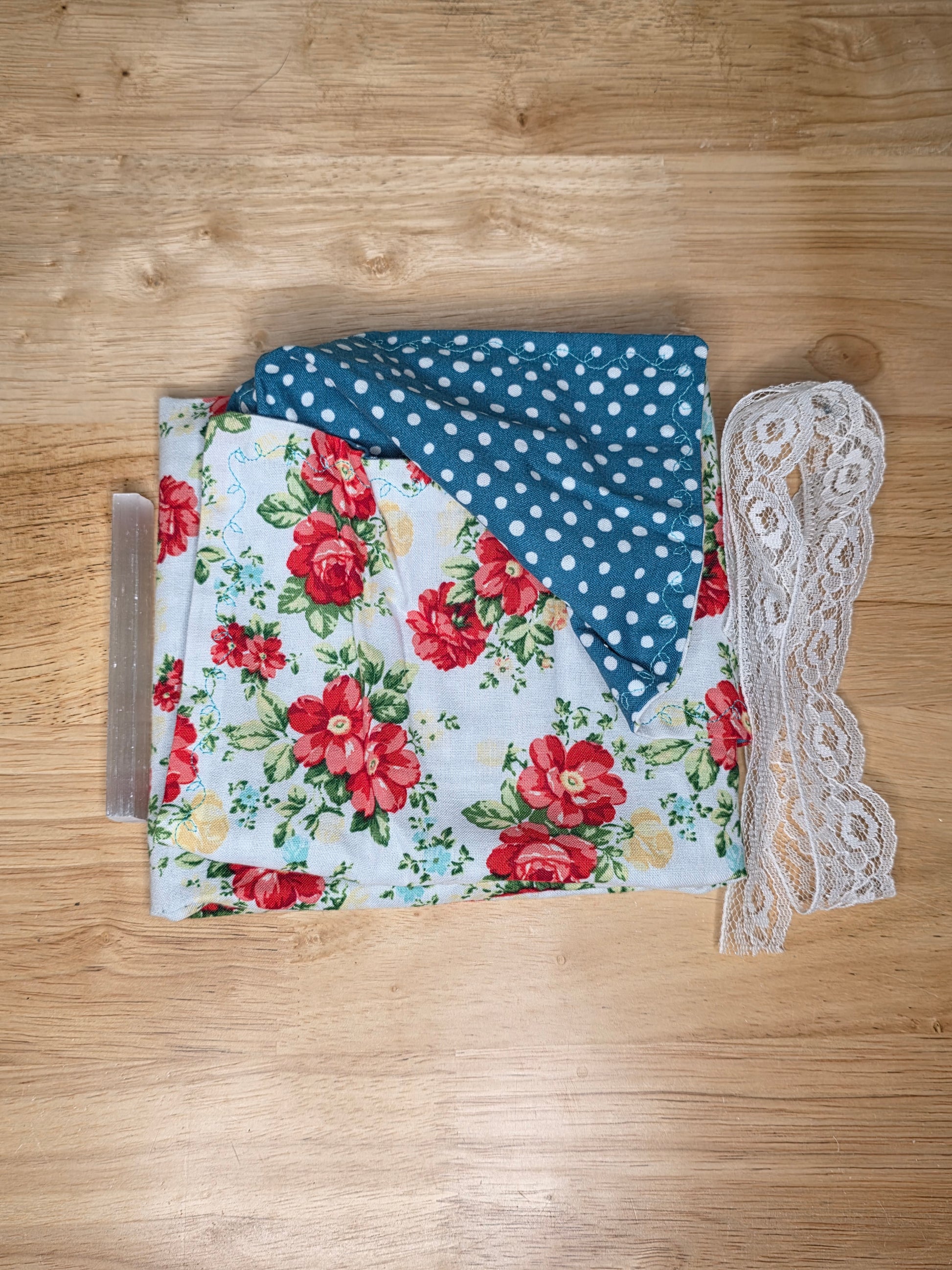 Reversible rose-pattern tarot wrap with teal polka dot fabric, ivory lace tie, and selenite stick.