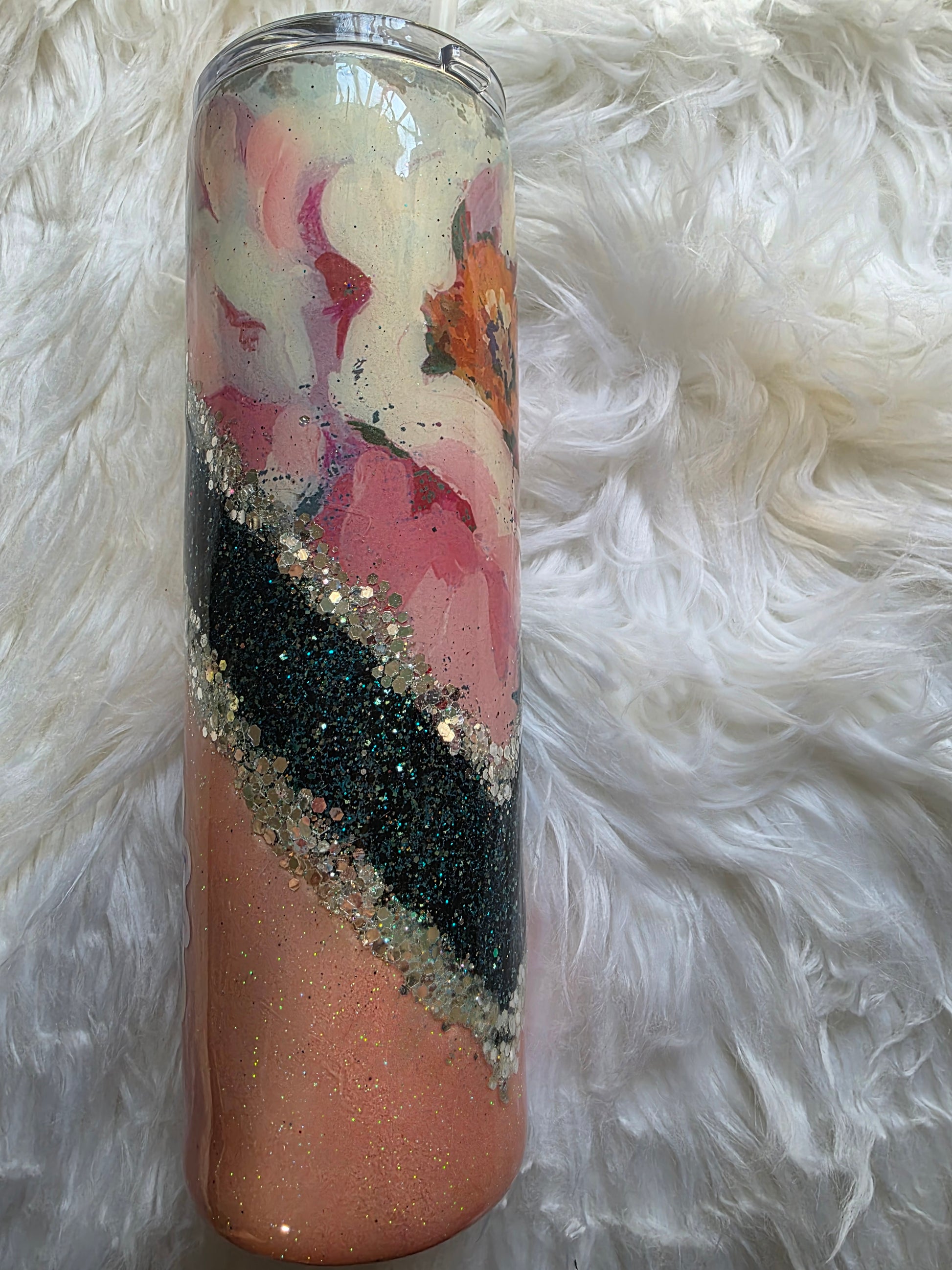 Side angle of handmade floral glitter tumbler showing layered epoxy shimmer and pink, peach, and teal hues