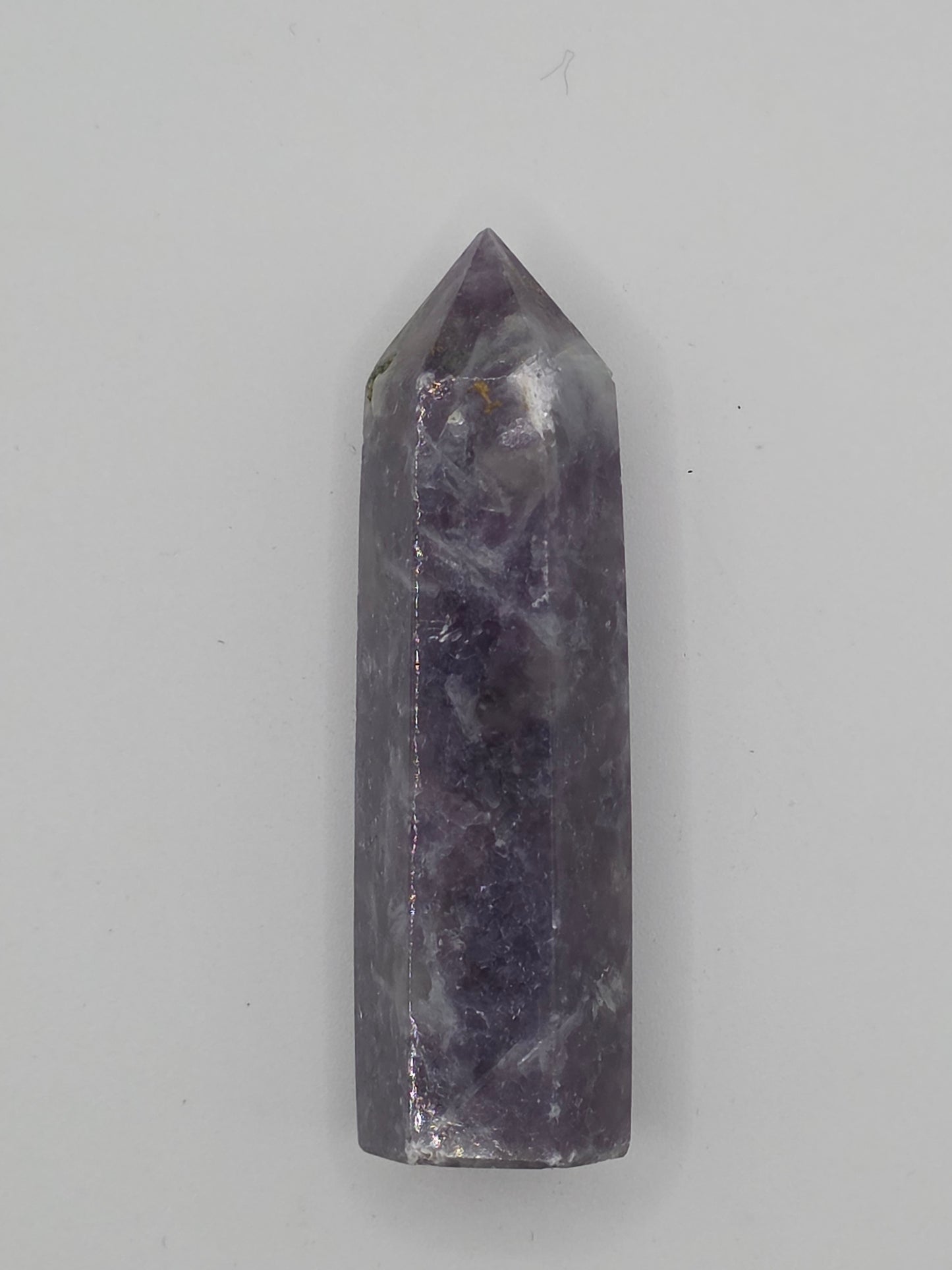 Lepidolite tower with lavender-gray tone and mica shimmer on white background.