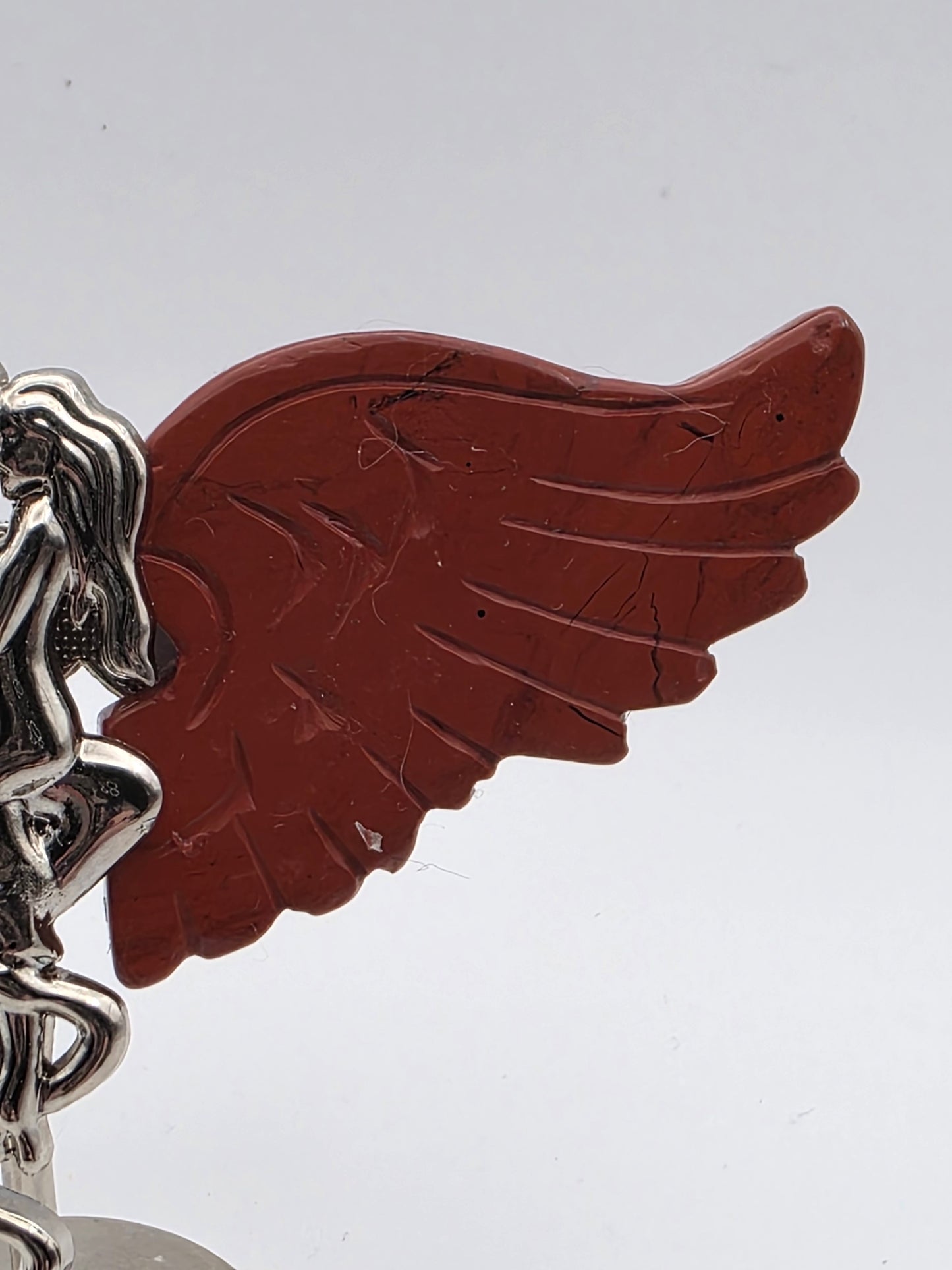 Close-up of Red Jasper wing with deep brick-red tones and grounding energy.