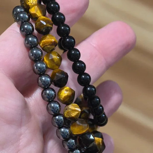 Power Protection bracelet stack featuring obsidian, hematite, and faceted tiger’s eye beads for grounding, confidence, and energetic protection.