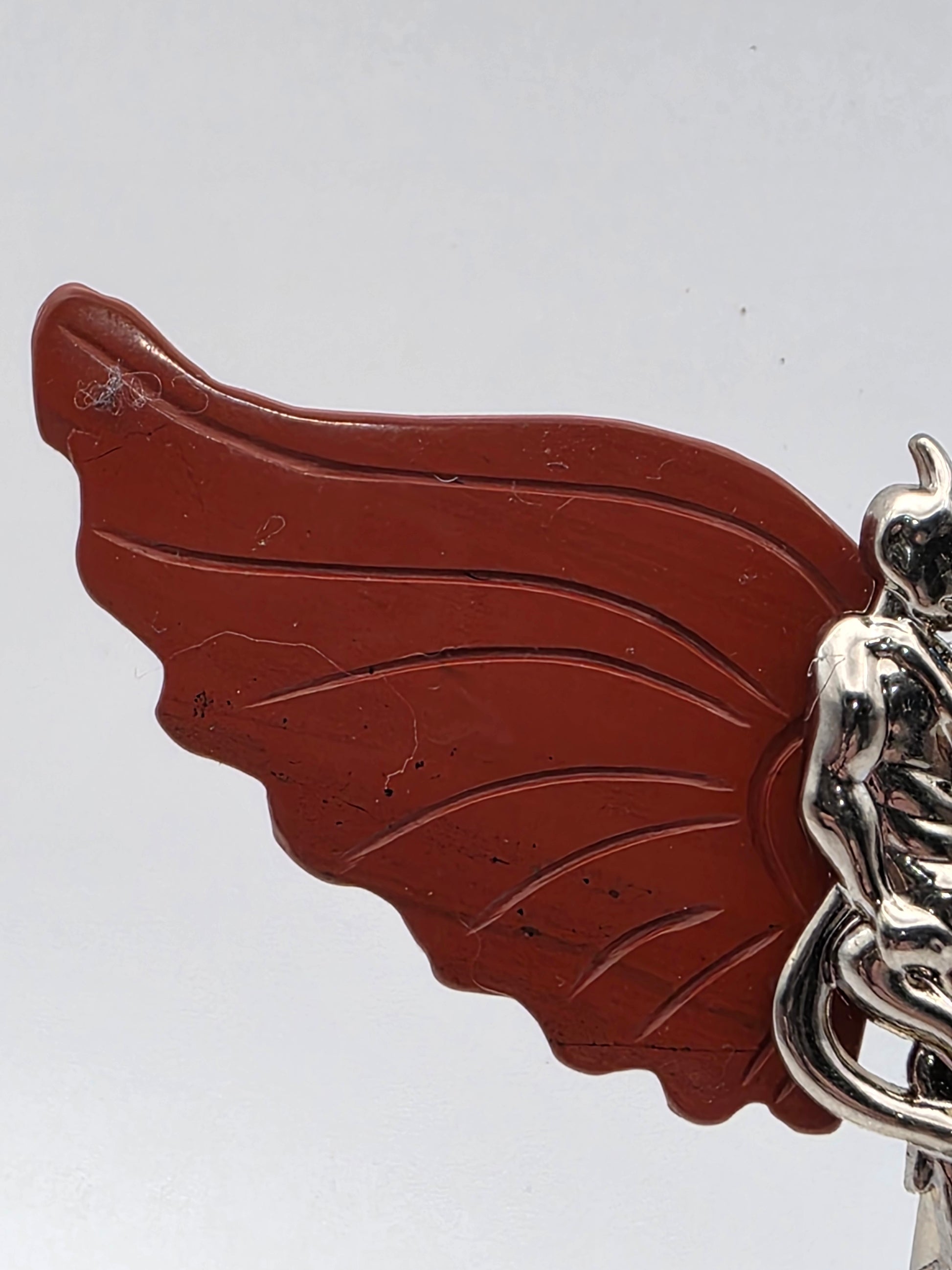 Close-up of Red Jasper wing showing earthy red tones and natural texture.