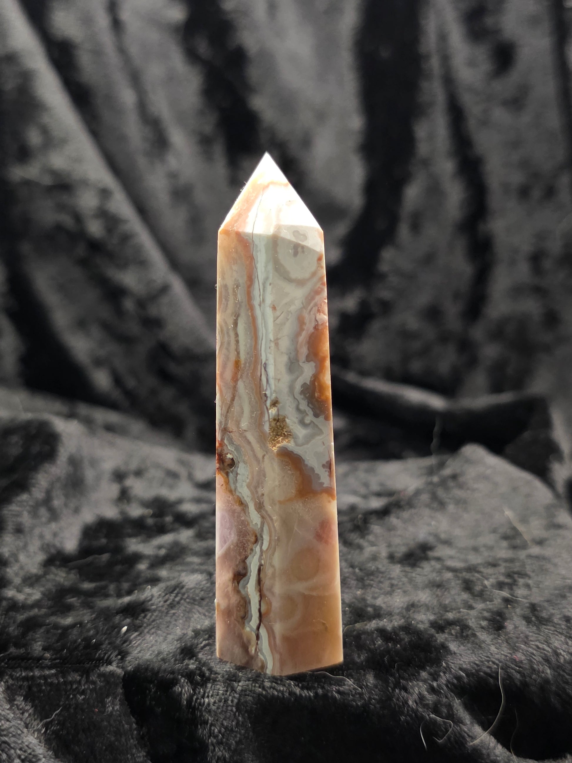 Amethyst & Crazy Lace Agate tower crystal point front view on textured black background showing orange and cream bands