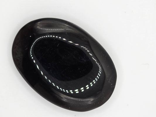 Smoky Quartz palm stone resting on white surface showing soft reflective shine.