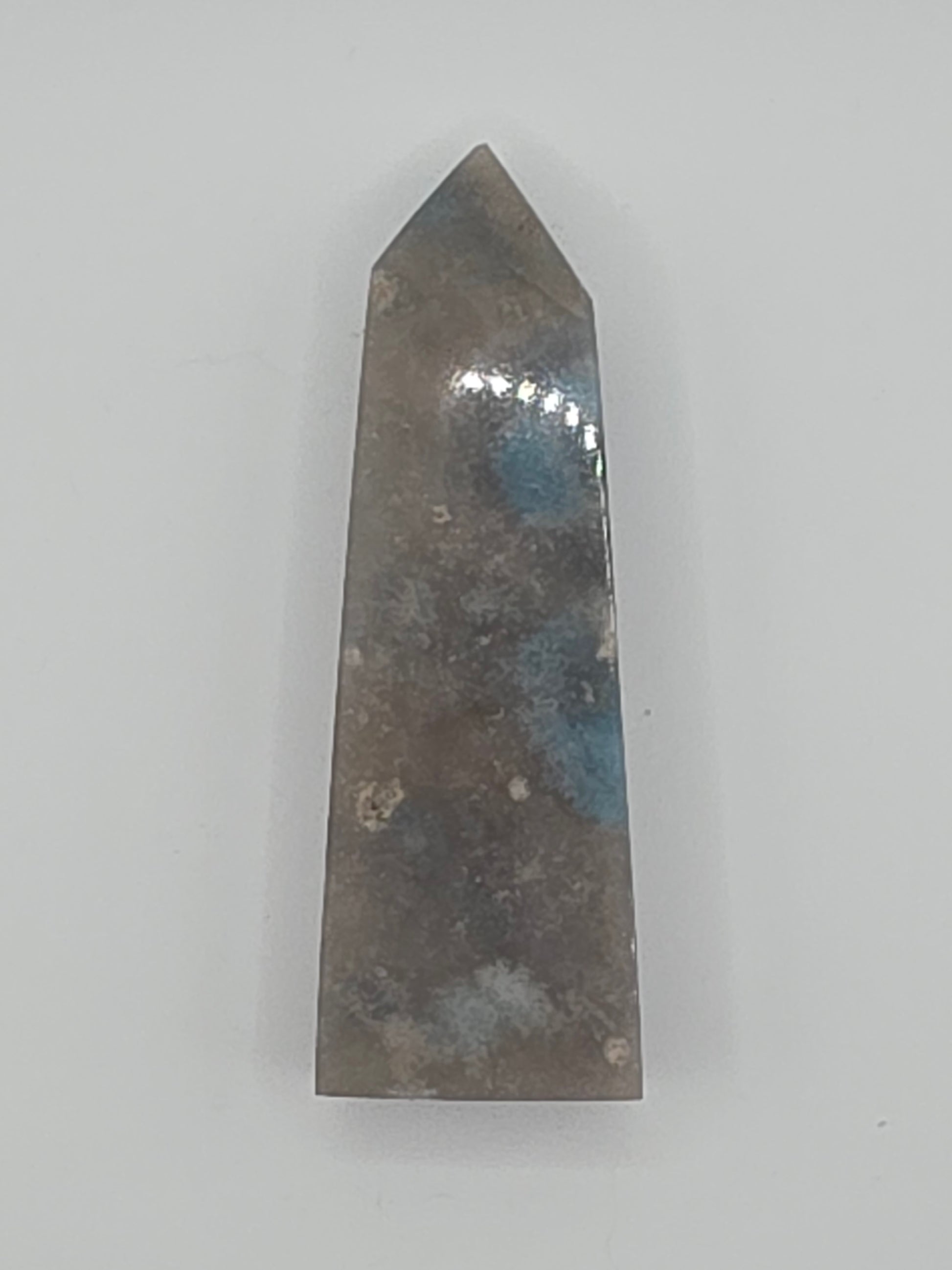 Trolleite tower with blue-gray clouds and subtle white marbling on a white background.