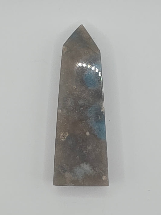 Trolleite tower with blue-gray clouds and subtle white marbling on a white background.